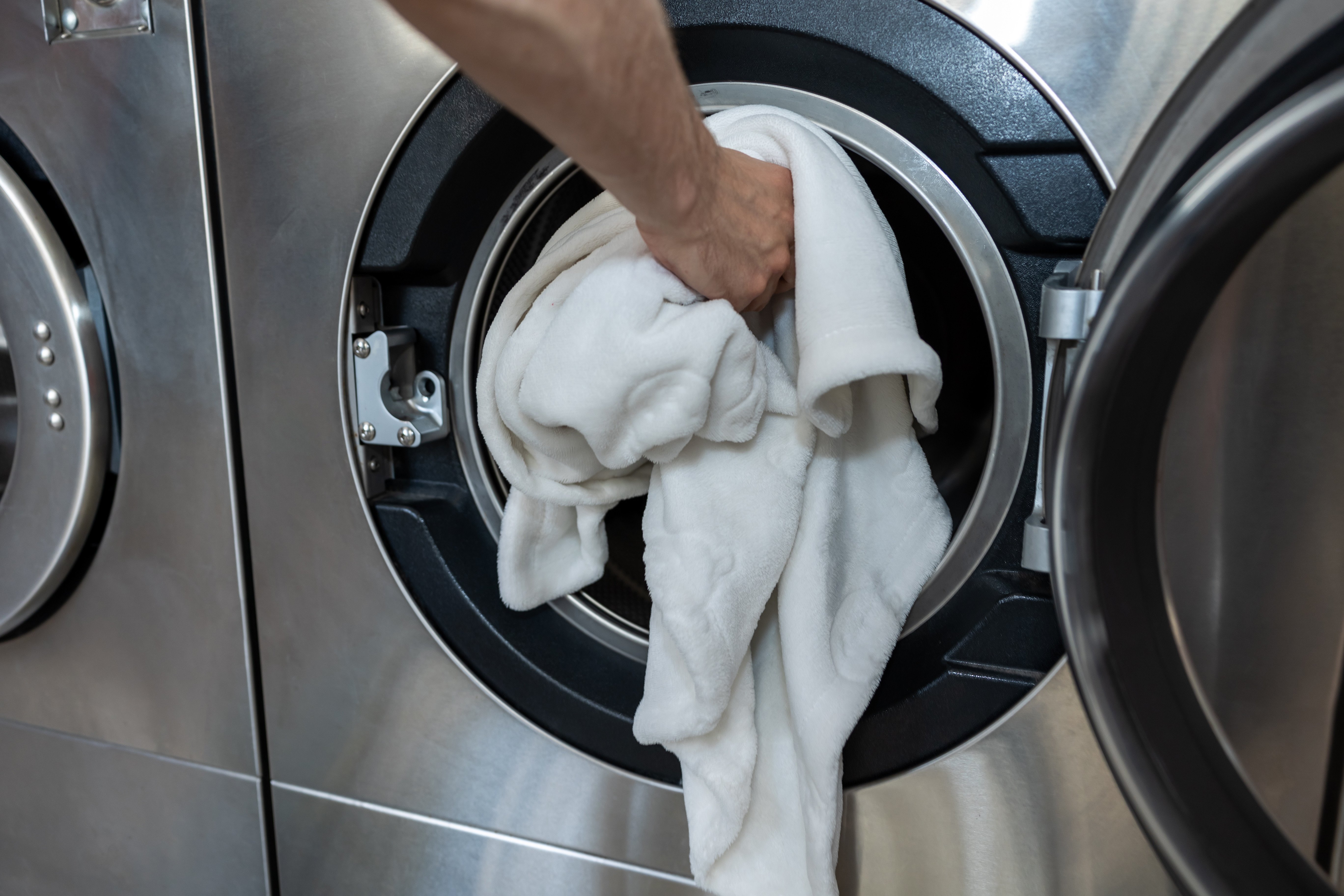 Person putting laundry into machine