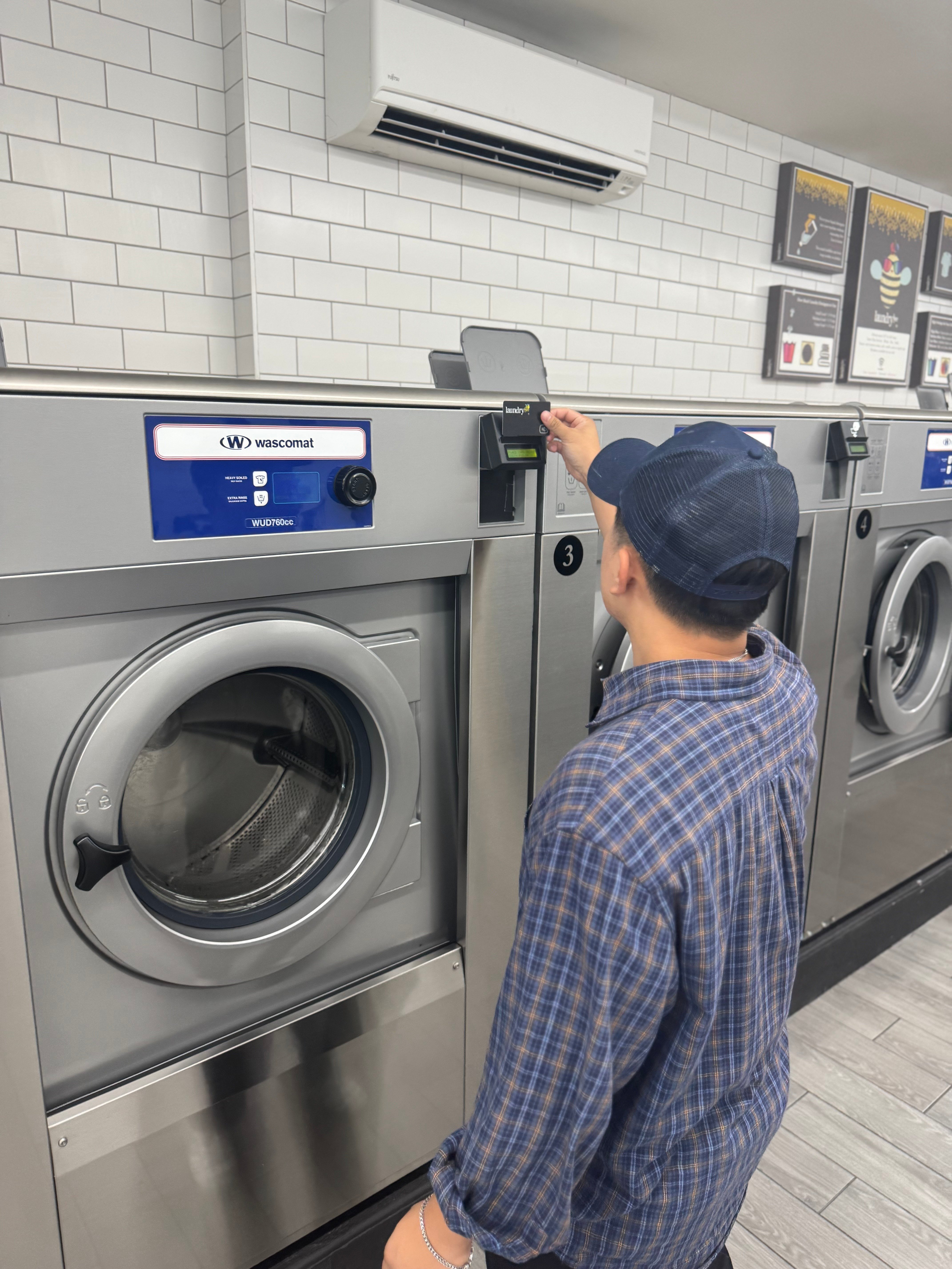 Customer using card reader in laundromat